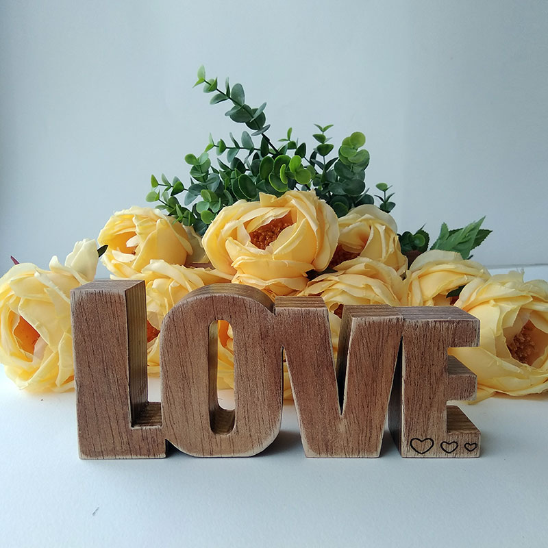 palabra LOVE de madera maciza y envejecida con tres corazoncitos grabados a la derecha