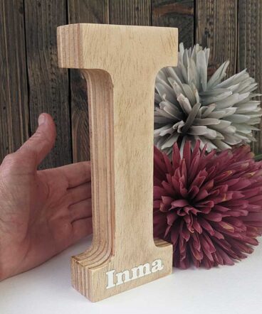 Letra I de madera maciza con el nombre de Inma pintado en blanco en la parte de abajo