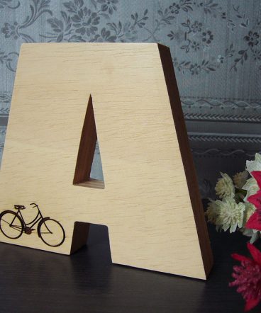Letra A grabada con bici hecha en madera natural