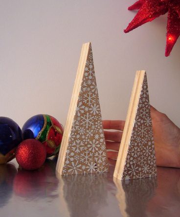 dos árboles de navidad de madera maciza natural con forma de triángulos alargados, grabados con copos de nieve pintados de blanco