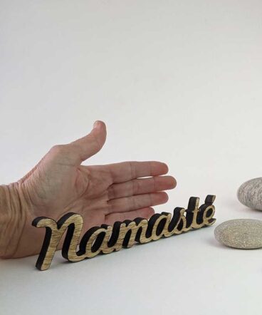 palabra namasté de madera envejecido sobre fondo blanco y palma de una mano para ver tamaño
