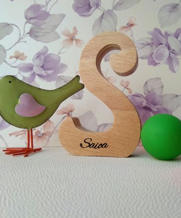 Letra S de madera personalizada con el nombre de Saioa sobre fondo con flores malva y pajarito verde a la izquierda