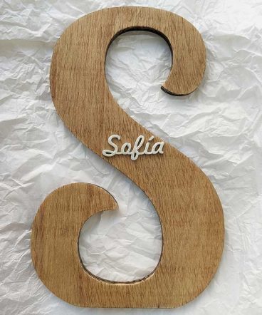 fondo de papel blanco arrugado con letra S de madera decorada con el nombre de Sofía en blanco y en relieve pegado en el centro