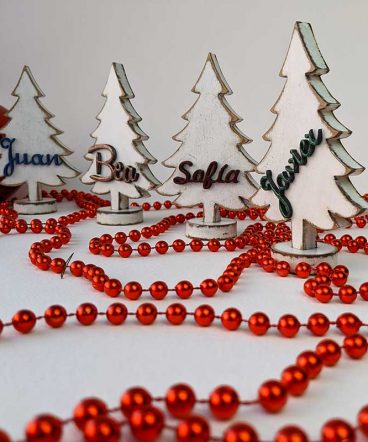 cuatro árboles de navidad pequeños y blancos personalizados con nombres en relieve
