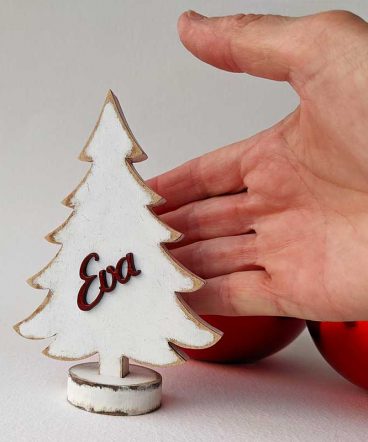 mano detrás de árbol de navidad blanco y pequeño personalizado con nombre eva