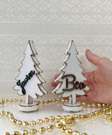 mano sujetando dos árboles de navidad pequeños color blanco personalizados
