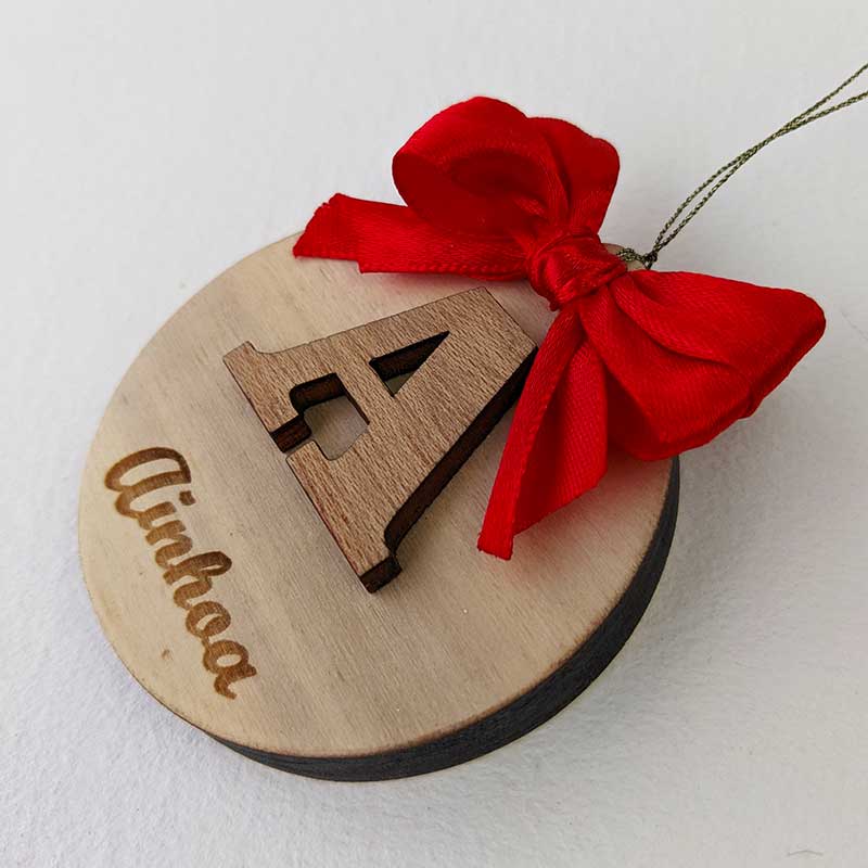 círculo de madera personalizado con letra en relieve y nombre grabado