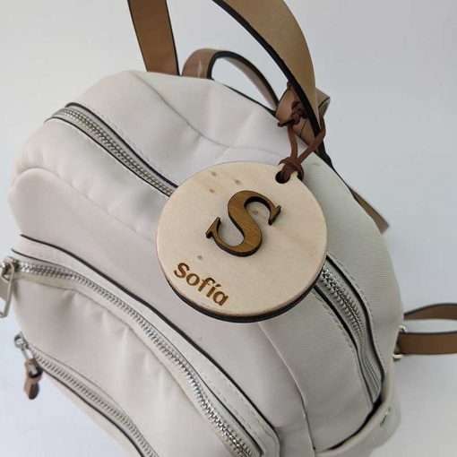 mochila blanca vista desde arriba con colgante redondo de madera personalizado