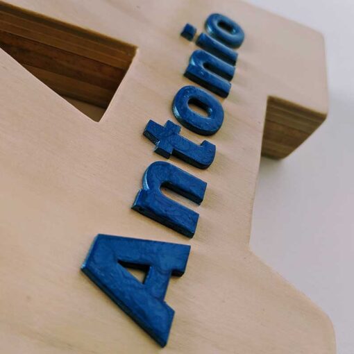 Detalle del nombre de Antonio en relieve color azul y pegado sobre letra A de madera