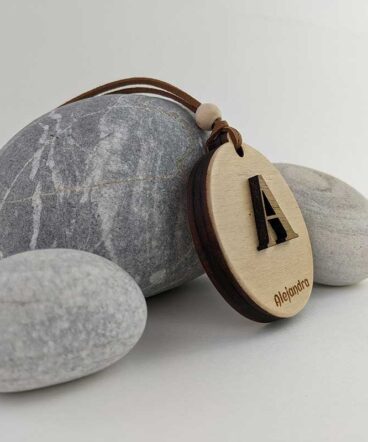 círculo de madera con nombre Alejandra grabado y letra en relieve en el centro