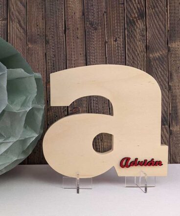Letra a de madera natural con el nombre de Adrián color rojo y en relieve pegado en la parte de abajo