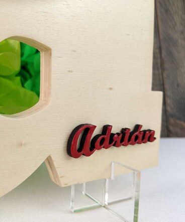 detalle de letra A de madera natural con el nombre de Adrián en color rojo y en relieve en la parte baja