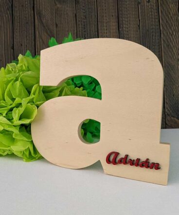 Letra a de madera natural con el nombre de Adrián color rojo y en relieve en la parte baja a la derecha