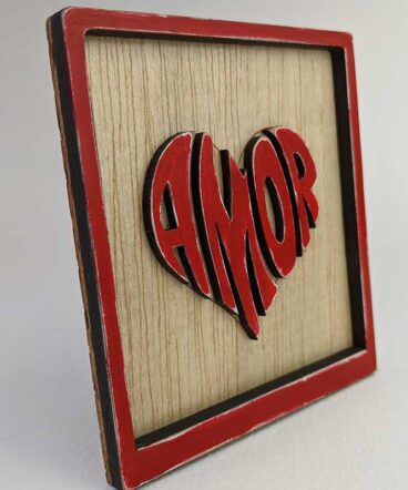 vista lateral de cuadrito con el fondo de madera y con la palabra amor en el centro con forma de corazón y roja