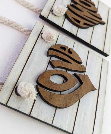 Pequeño tablero color blanco con la palabra LOVE de roble en el centro en relieve y con forma de corazón