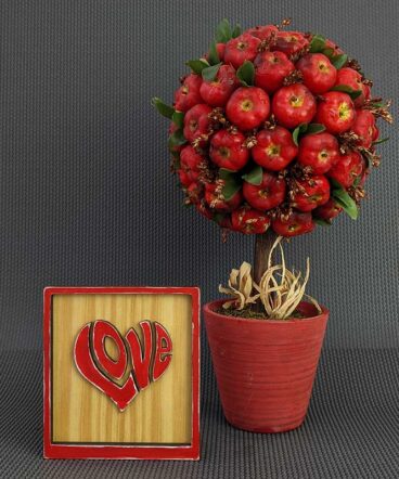 cuadrito de madera con marco y la palabra LOVE en rojo y en relieve con forma de corazón