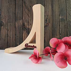 Letra A de madera natural personalizada con el nombre de Aarón color burdeos y en relieve pegado en el trazo del centro