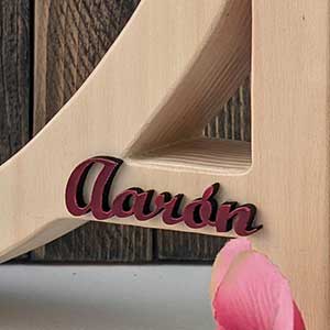 Letra A de madera natural personalizada con el nombre de Aarón color burdeos y en relieve pegado en el trazo del centro