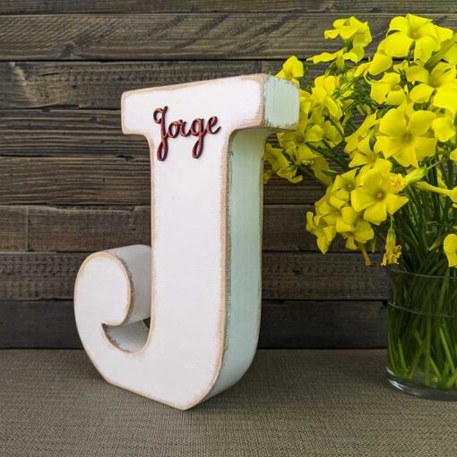 letra j blanca con bordes color madera, con el nombre de Jorge de color rojo y en relieve pegado en la parte de arriba