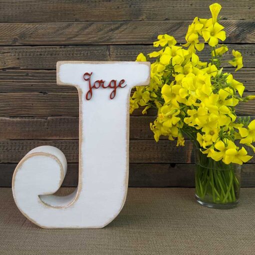letra j blanca con bordes color madera, con el nombre de Jorge de color rojo y en relieve pegado en la parte de arriba