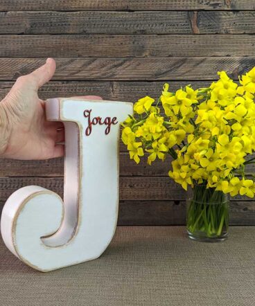 letra j blanca con bordes en madera, con el nombre de Jorge de color rojo y en relieve pegado en la parte superior