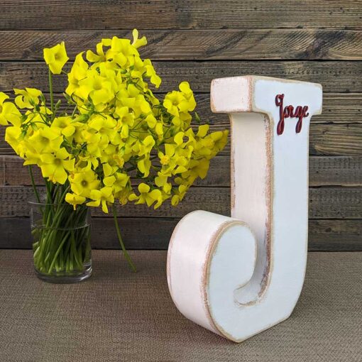 letra j blanca con bordes envejecidos color madera, con el nombre de Jorge de color rojo y en relieve pegado en la parte de arriba
