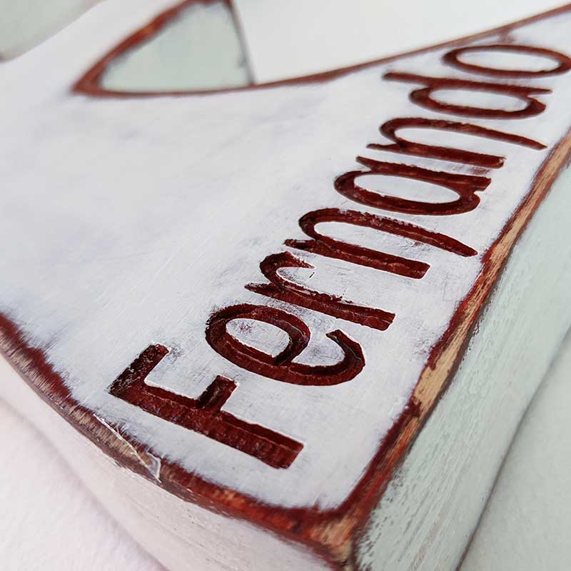 Detalle de nombre Fernando grabado y pintado en burdeos sobe letra F blanca