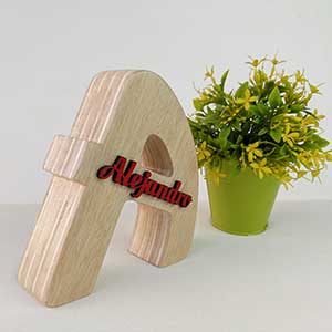 letra de madera natural con el nombre de Alejandro en relieve y color rojo pegad en el centro