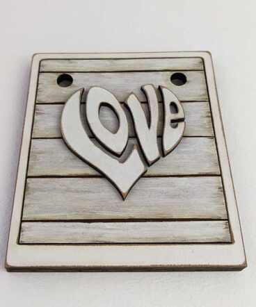 detalle de tablero con marco color blanco vintage con LOVE en el centro en relieve y con forma de corazón
