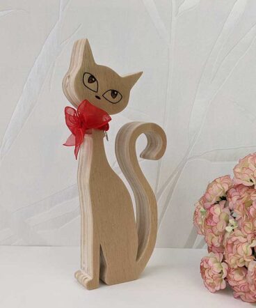 silueta de gato de madera con los ojos grabados y lazo rojo en cuello
