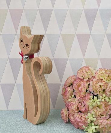 silueta de gato de madera con los ojos grabados y un lazo rojo en cuello