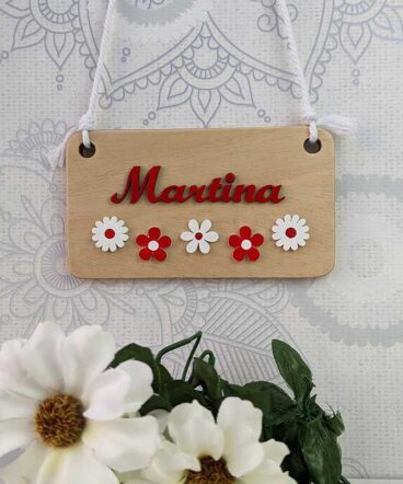 Letrero de maderacon el nombre de martina en rojo con flores blancas y rojas