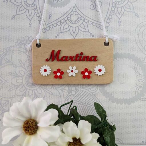 Letrero de maderacon el nombre de martina en rojo con flores blancas y rojas