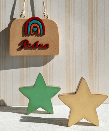 letrero de madera con arcoiris y nombre en rojo