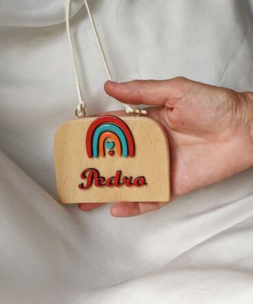 letrero de madera con arcoiris y nombre en rojo